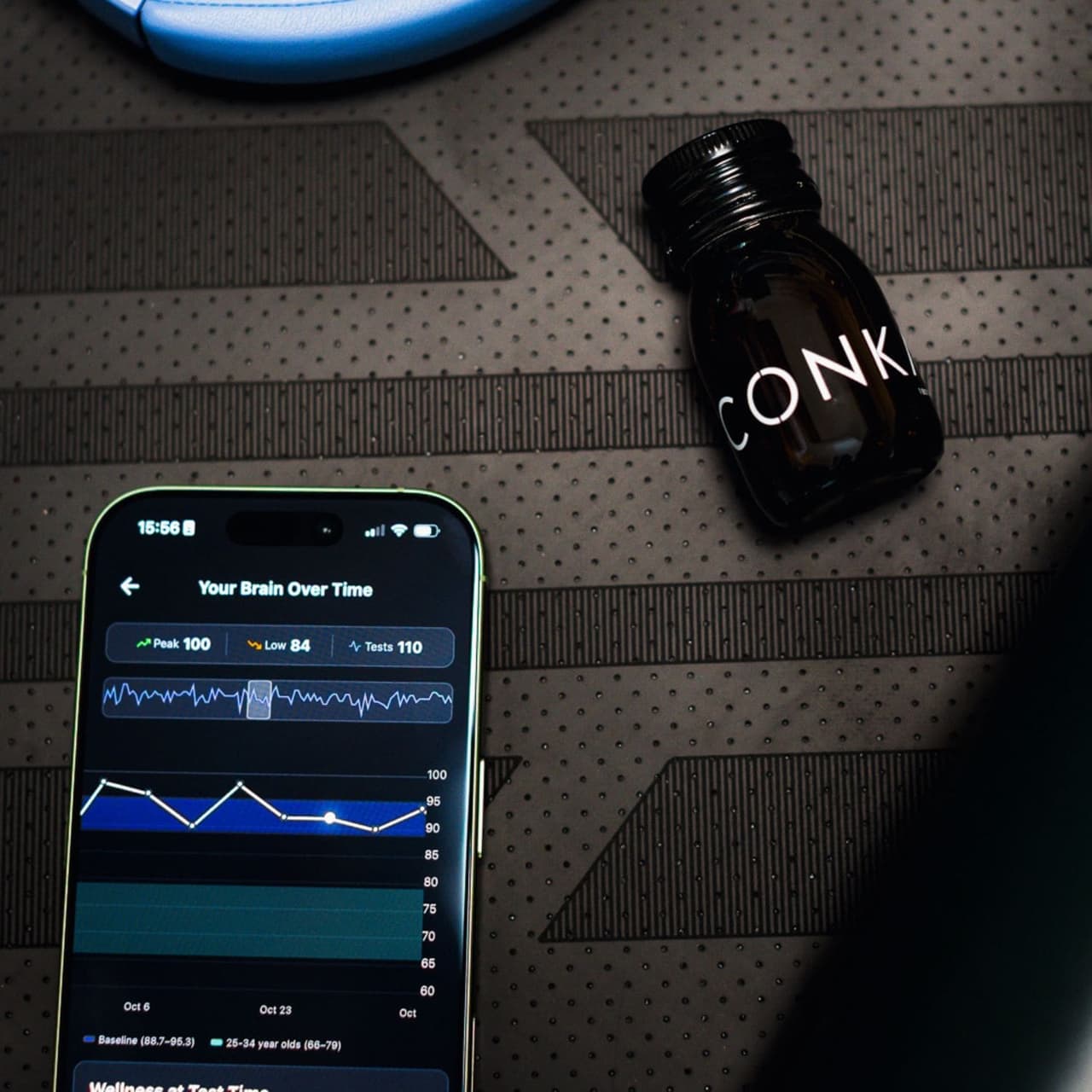The CONKA app showing a brain score over time, beside a CONKA shot on a yoga mat