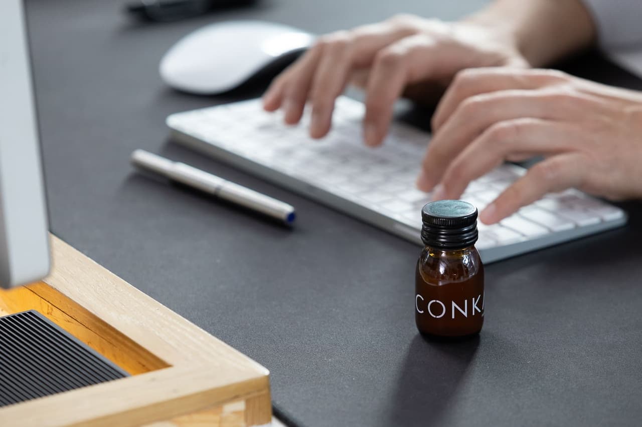 CONKA bottle on a work desk beside a keyboard
