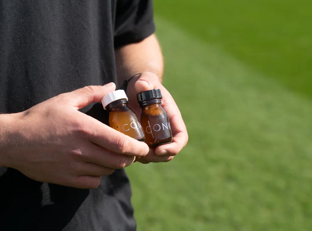 Two CONKA shots held pitchside before training
